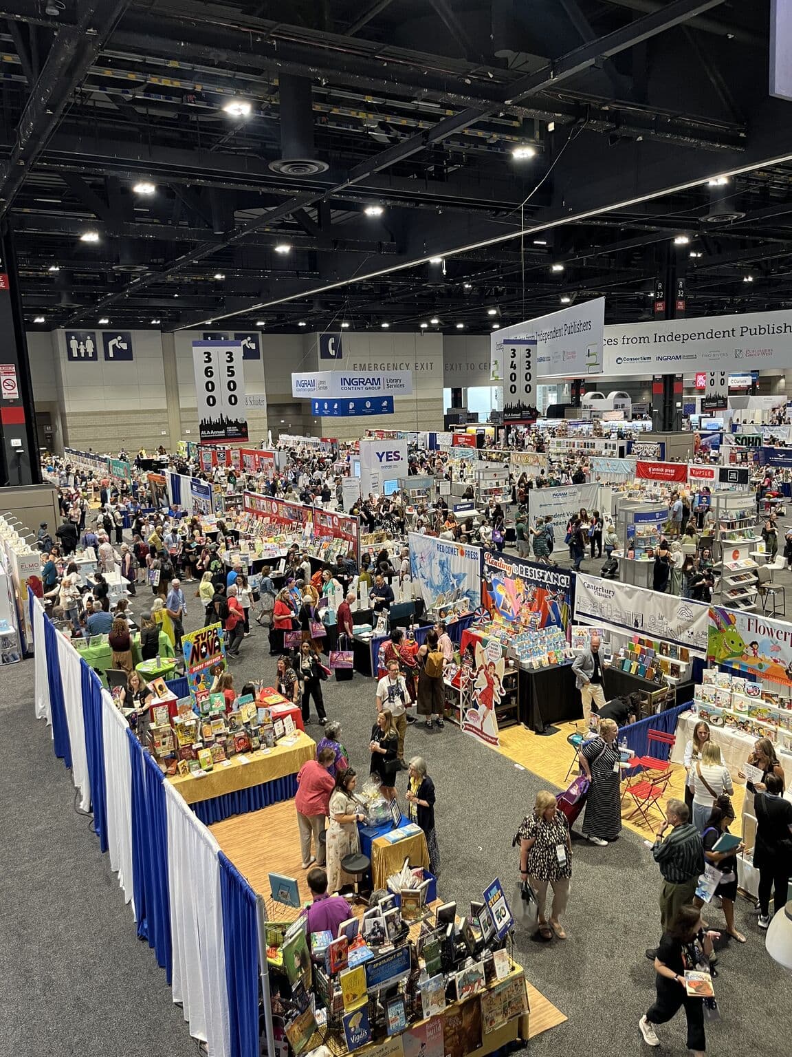 The ALA exhibit hall at McCormick Place seen from above: long rows of publisher booths and crowds of librarians moving among the book displays.